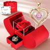 A gold heart pendant necklace is displayed alongside a red gift box containing a red rose and a small pendant.