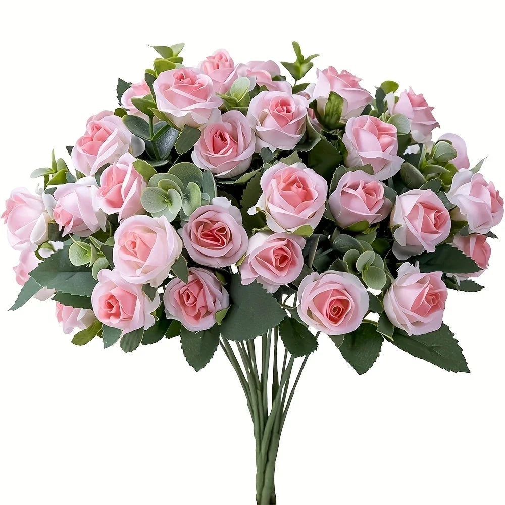 A bouquet of pink silk roses and green eucalyptus leaves for wedding or home decor.