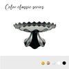 A silver-colored, scalloped plastic cake stand.