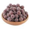 A pile of small, textured, glittery resin beads in various shades of brown and purple.