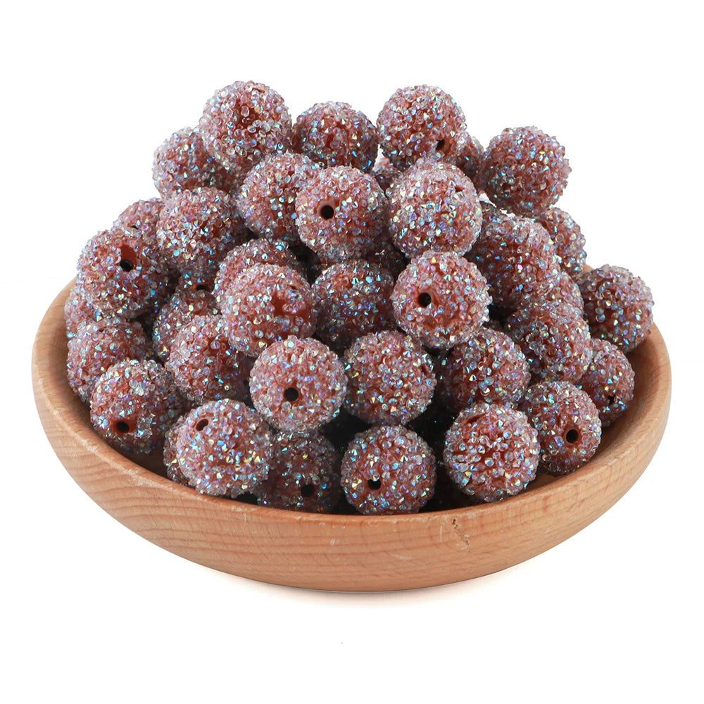 A pile of small, textured, glittery resin beads in various shades of brown and purple.
