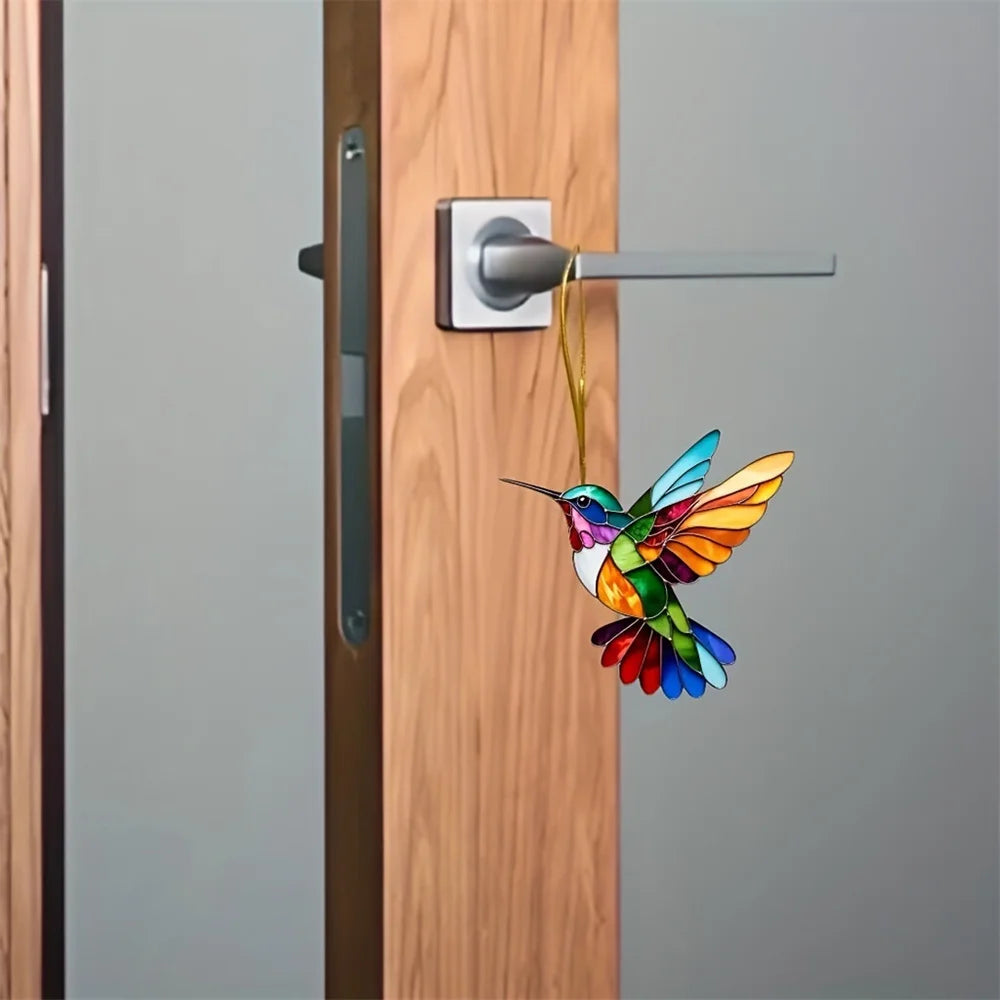 A colorful acrylic hummingbird suncatcher hanging ornament is displayed on a wooden door.