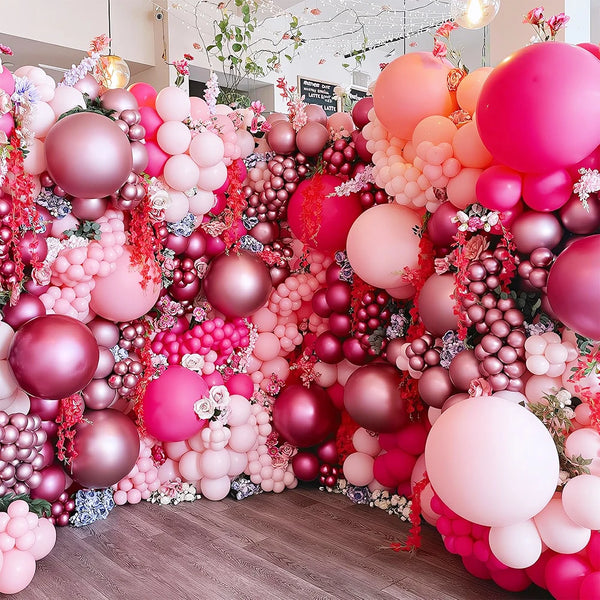 Una densa disposición de globos metálicos rosa y oro rosa creando un fondo floral para un evento.