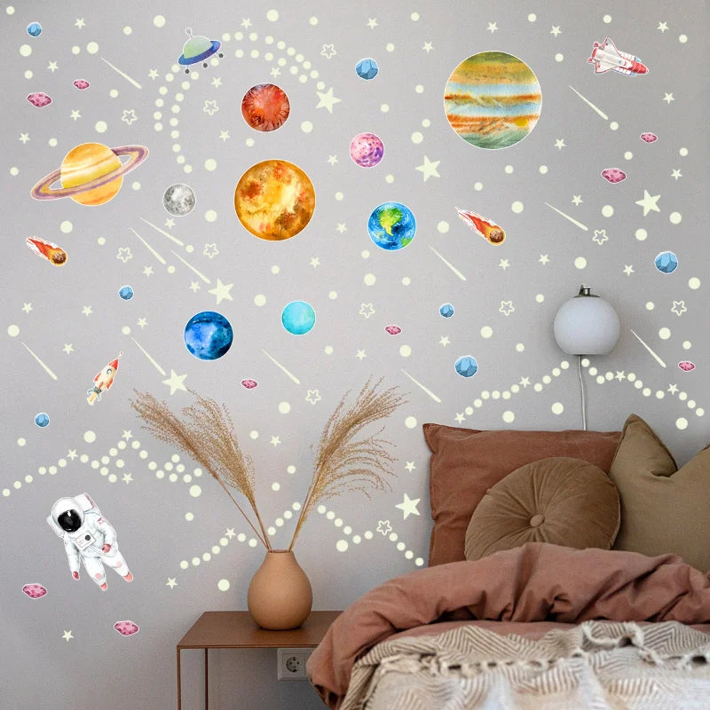 Pared de dormitorio decorada con estrellas y planetas luminiscentes y una planta en maceta.