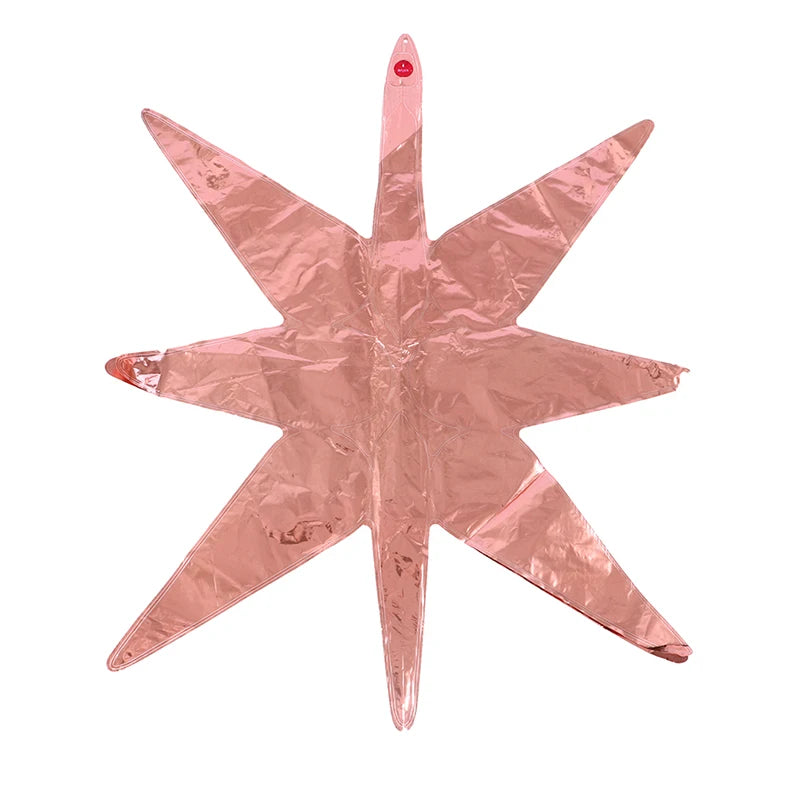 A pink star burst foil balloon with pointed arms for party decoration.