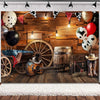 A rustic western backdrop featuring a wooden barn door, vintage wagon wheel, guitar, barrel, and balloons.