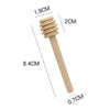 A wooden honey dipper stick with measurements indicating its size.