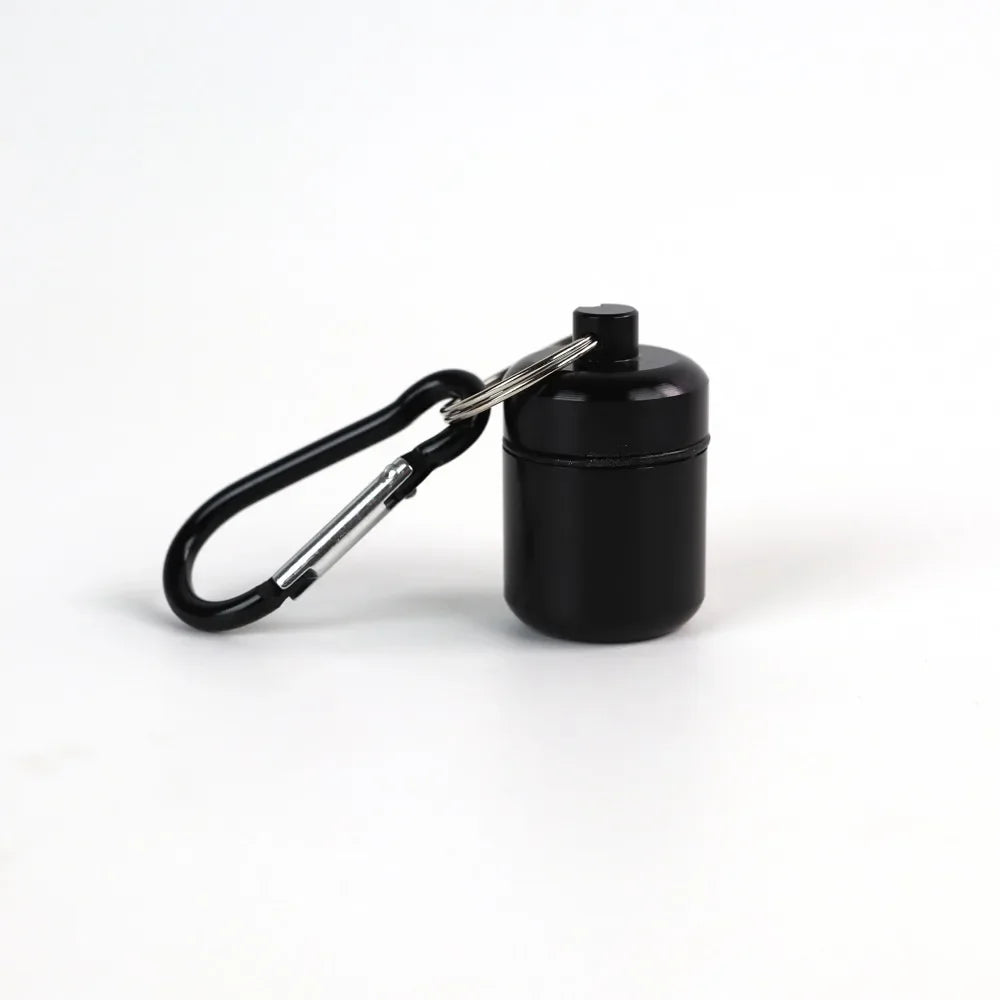Black mini waterproof pill organizer keychain with a metal keyring