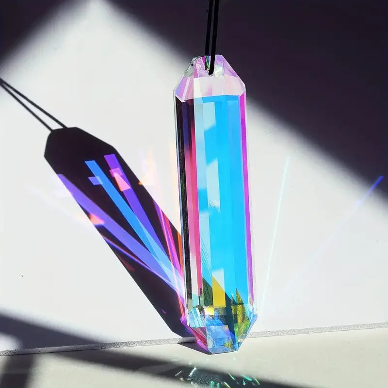A pair of prismatic crystal pendants featuring vibrant blue and rainbow colors casting light shadows on a white surface.