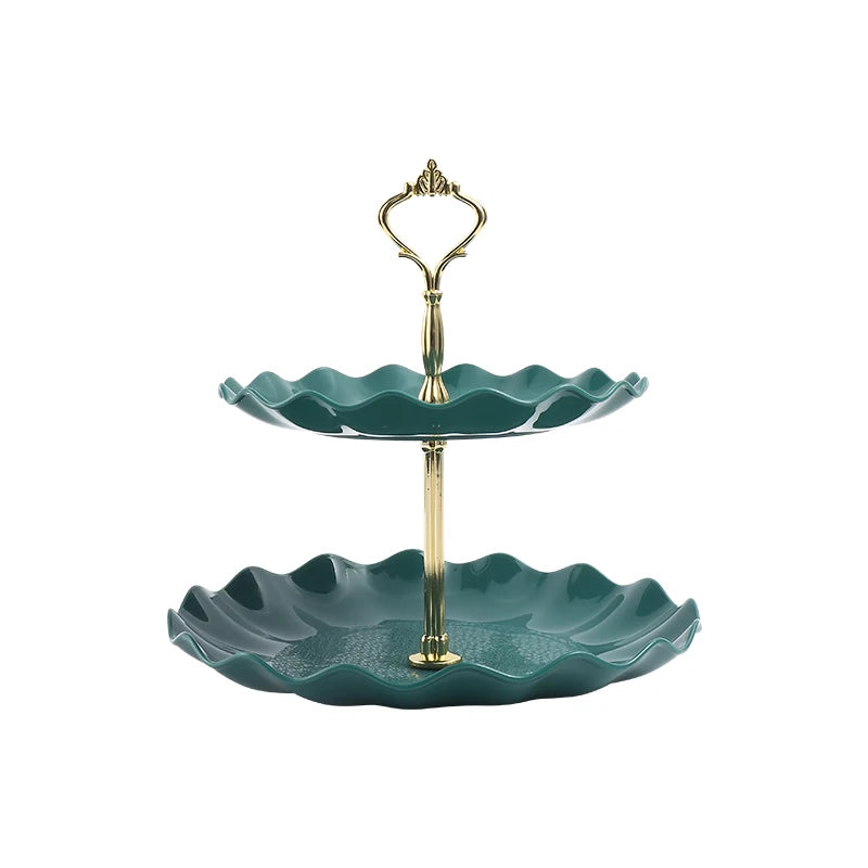 A two-tier serving stand with a brass-toned metal frame and two shallow, scalloped green ceramic dishes.