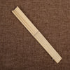Un éventail main squelette en bambou pliante et mince posé sur un fond de tissu tissé marron.