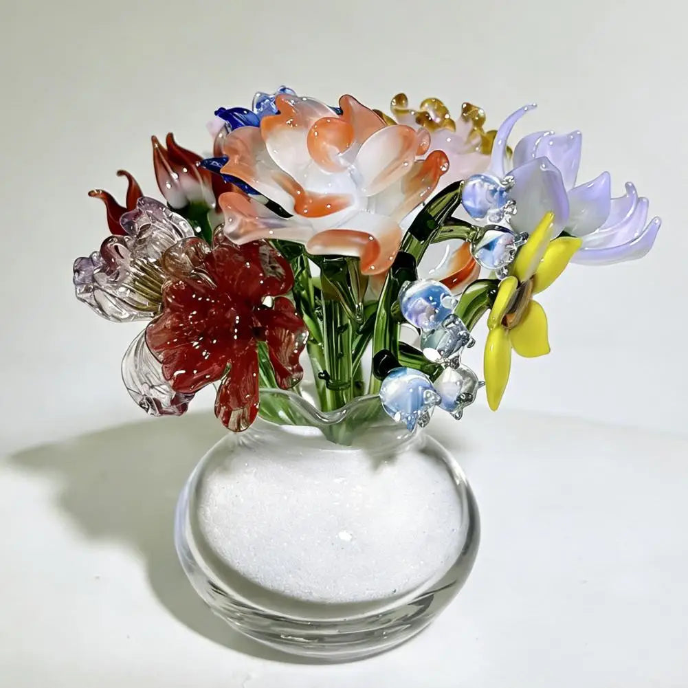 Handcrafted blue glass flower sculpture featuring various colored petals and stems in a clear glass vase.
