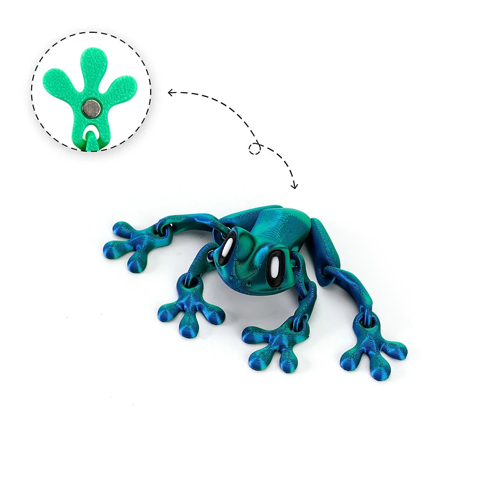A teal articulated 3D printed frog magnet with green fingers and a small metal piece.