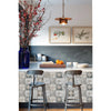 A kitchen backsplash featuring patterned tiles, a wooden countertop, and bar stools beneath a hanging light.