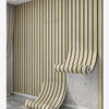 A roll of self-adhesive wood grain wallpaper is displayed against a vertical slat wall in a modern interior.