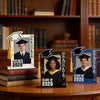 A graduation photo frame featuring a graduate in a black cap and gown, displayed on a wooden surface.