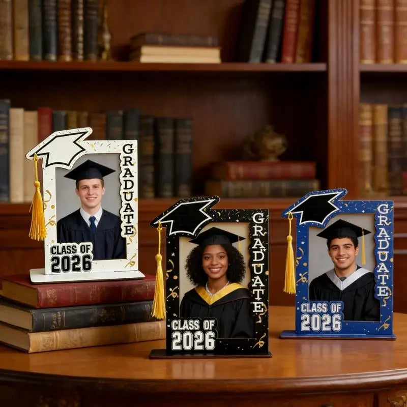 A graduation photo frame featuring a graduate in a black cap and gown, displayed on a wooden surface.