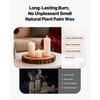 A set of glass cylinder pillar candles displayed on a wooden slab with a blurred background.