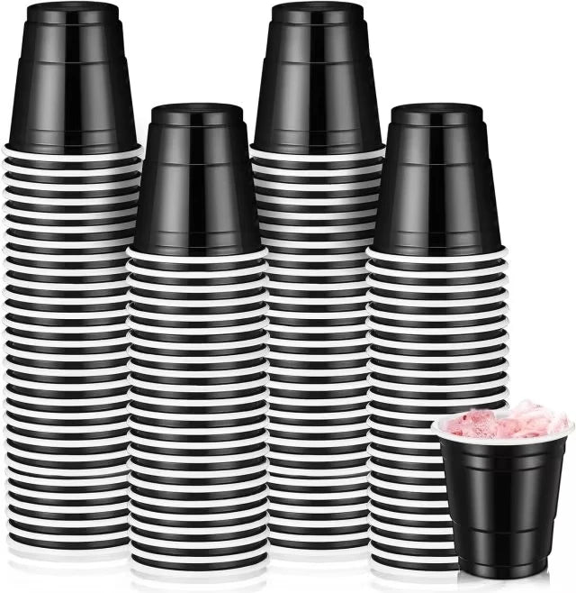 A set of black and white striped mini plastic shot cups for parties and events.
