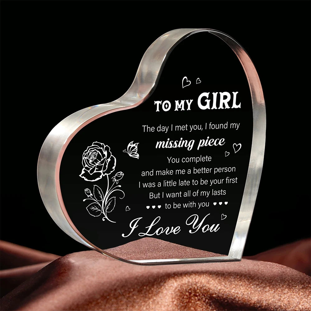 A heart-shaped clear acrylic keepsake with engraved text saying I love you and a message to my girl