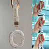 A sparkling crystal letter keychain charm in gold and silver tones, featuring a circular letter design.