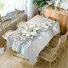 Elegant white lily flower rectangular tablecloth displayed on a wooden dining table with chairs.