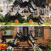Giant black plush spiders decorating a porch and staircase for Halloween
