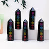 A set of black obsidian crystal towers with colorful gemstone carvings displayed on a white surface.