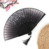 Black folding fan with sheer fabric and decorative elements next to a woven bamboo mat.