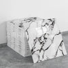 A stack of rectangular faux marble self-adhesive wall tiles with white and black veining on a gray surface.