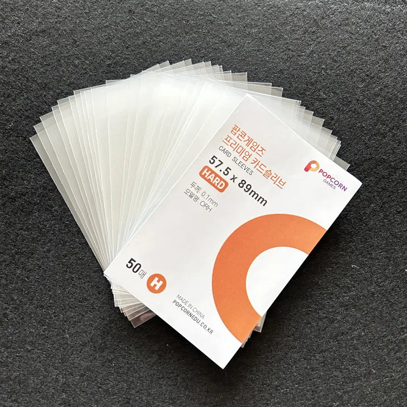 A stack of 50 clear hard card sleeves for cards, packaged in a cardboard sleeve.
