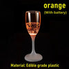 Une tasse en verre orange avec une lumière de batterie interne qui brille.
