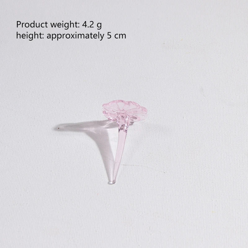 A delicate pink glass flower bouquet with a translucent stem and petals, shown against a white background.