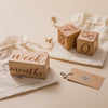 A set of wooden baby milestone cards featuring numbers and the text week months displayed on a light linen background.