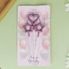 A set of pink and white balloons with heart and star shapes arranged on a rectangular card.