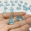 A hand holds a set of translucent blue glow in the dark resin sea animal figurines.
