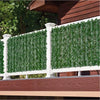 White fence panels featuring artificial green ivy hedge panels installed on a wooden deck.
