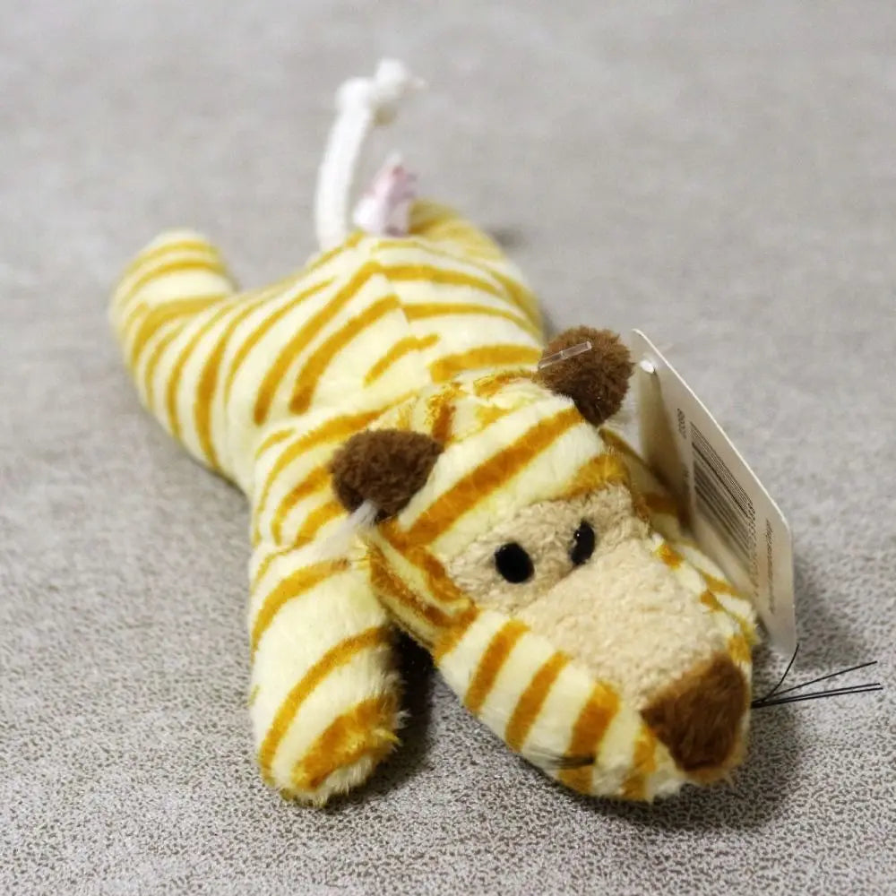 A yellow and orange tiger plush toy with brown accents, used as a fridge magnet.