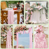 A collection of pink floral decor featuring a semi-sheer gauze table runner, pink draping, and rustic wedding elements.