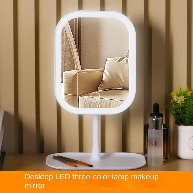 A white LED three-color lamp makeup mirror with a round frame and stand in a neutral indoor setting.