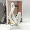 White artistic feather sculpture centerpiece displayed in front of a book titled Emma
