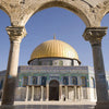 A golden dome and surrounding architecture of an Islamic mosque with columns and arches.