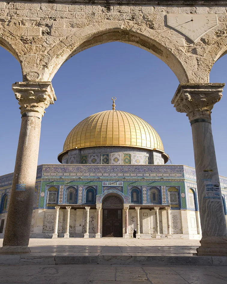A golden dome and surrounding architecture of an Islamic mosque with columns and arches.