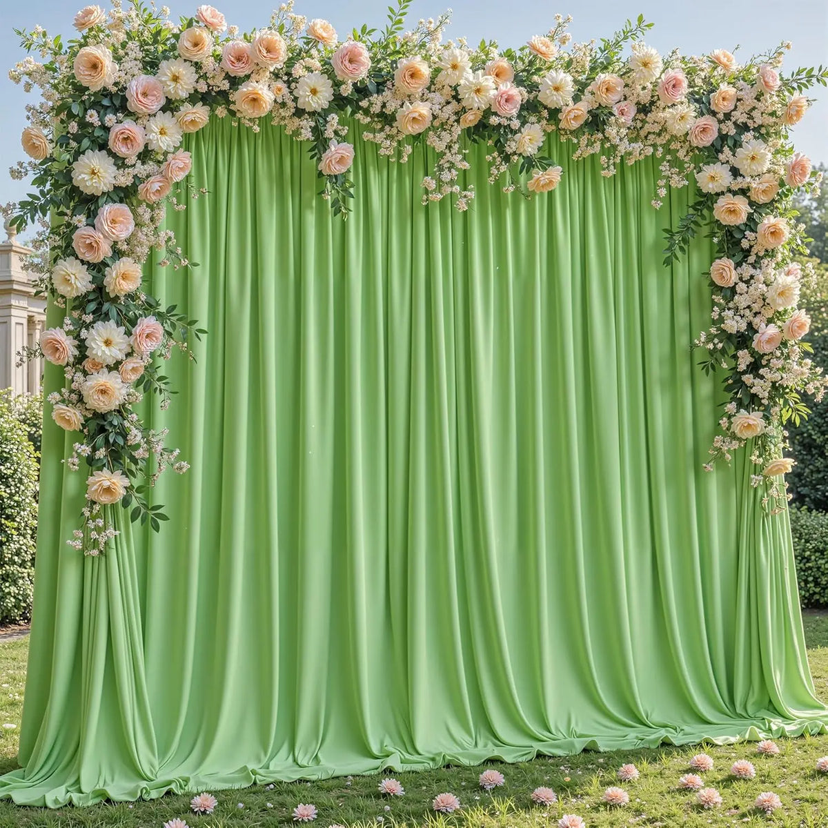 A lush floral backdrop featuring pink and white roses draped over a flowing lime green fabric curtain for an event.