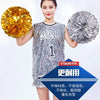 A young woman holds two spherical pom poms, one gold and one silver, against a white background.