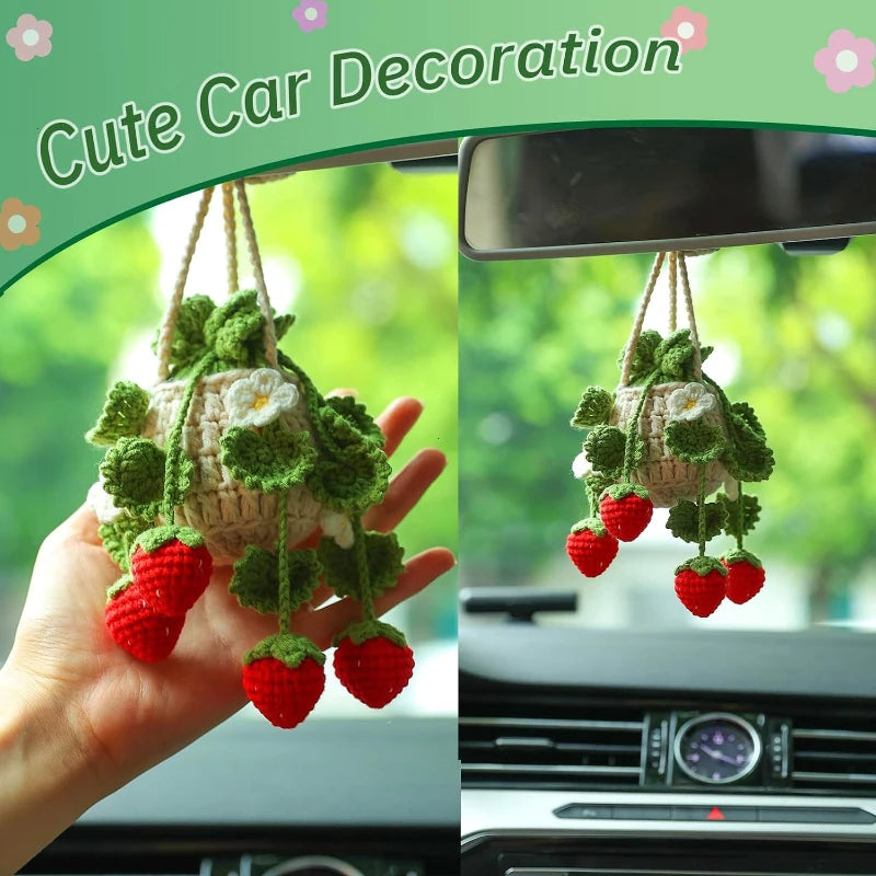Hand-knitted plant basket with red strawberries hanging from a car mirror.