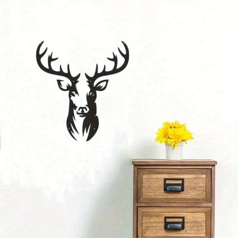 Black metal deer head wall sculpture with antlers on a white wall.