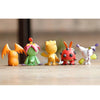 A set of nine colorful Digimon Adventure figures standing in a row on a wooden surface.