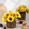 A bouquet of bright yellow artificial sunflowers in rustic wooden planters on a table.