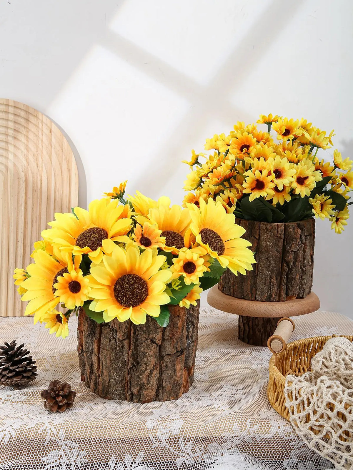 A bouquet of bright yellow artificial sunflowers in rustic wooden planters on a table.